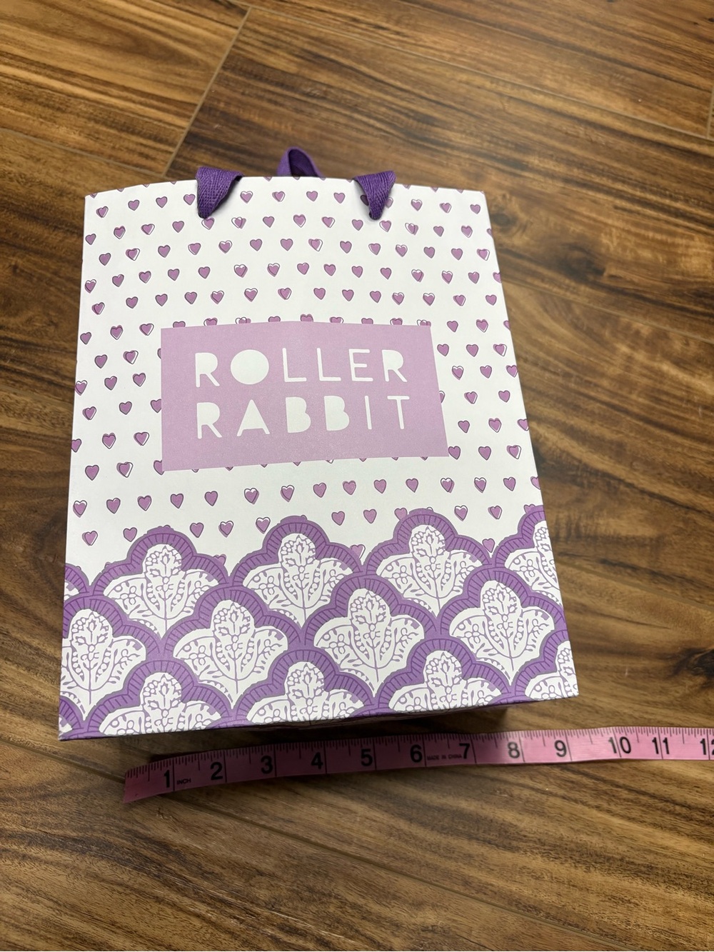 Roller Rabbit brand shopping gift bag featuring a white and purple heart pattern